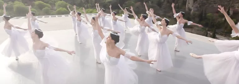 Ballerinas in white dance on a rooftop