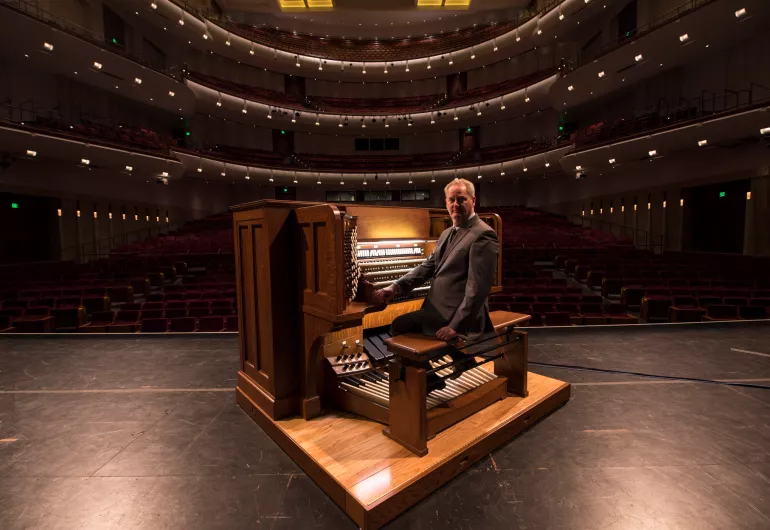 Dean Billmeyer sitting at the Northrop organ on the stage