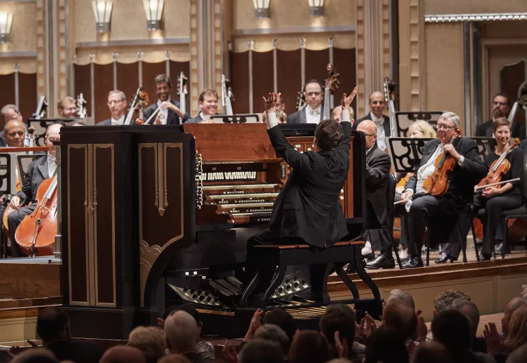 Paul Jacobs plays the organ on stage in front of a full orchestra.