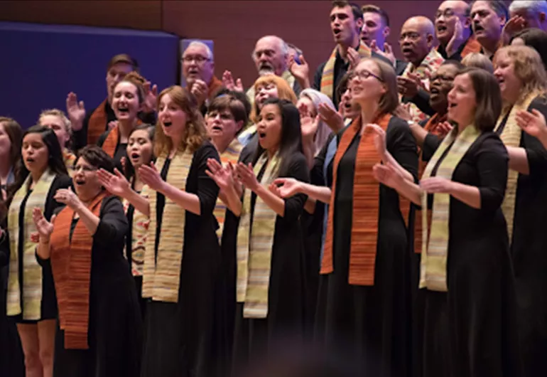 A large choir singing and clapping in unison.