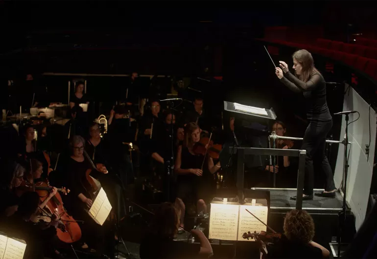 Conductor Dina Gilbert leads the orchestra