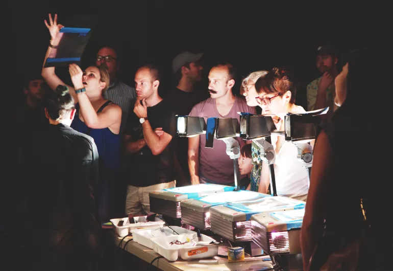 Manual Cinema crew working around overhead projectors