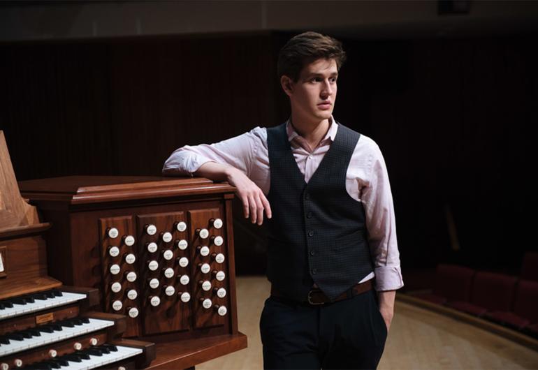 Greg Zelek poses with an arm on the organ