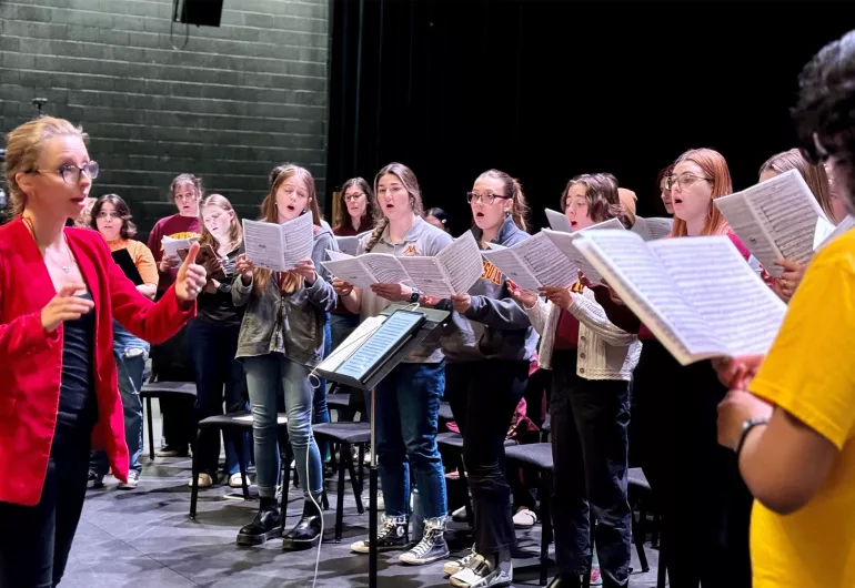 Anna Lapwood directs choir students.