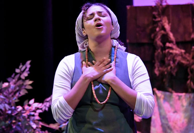 A woman with her eyes closed performing in the play” Kumbayah The Juneteenth Story.”