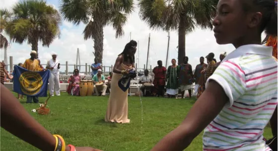 a group of people circle around a woman outside