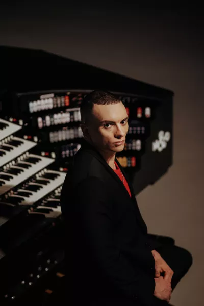 Cameron sitting with his back to the organ.