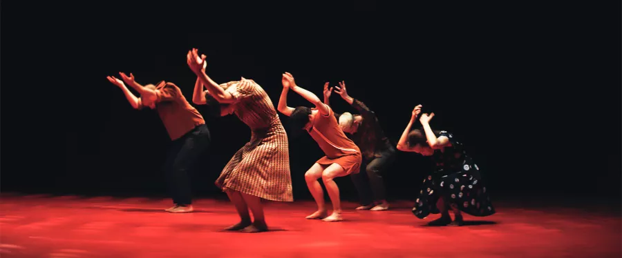 Dancers perform on red stage.