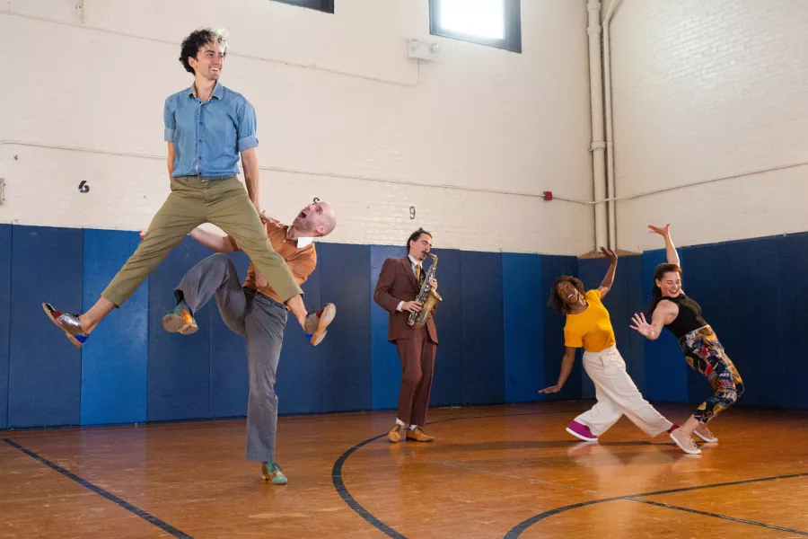 Swing 2020 dancers perform in a gymnasium setting.