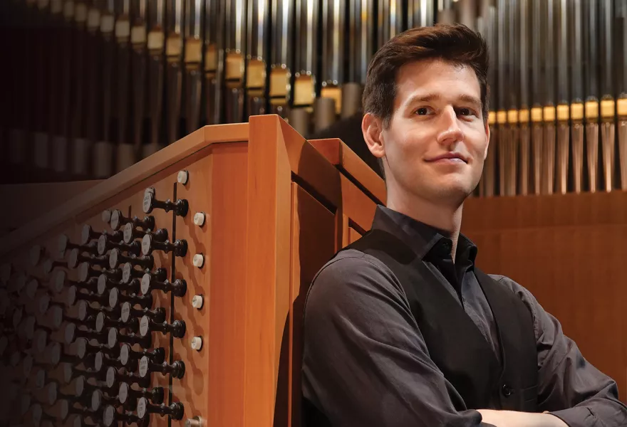 Greg Zelek standing in front of a pipe organ