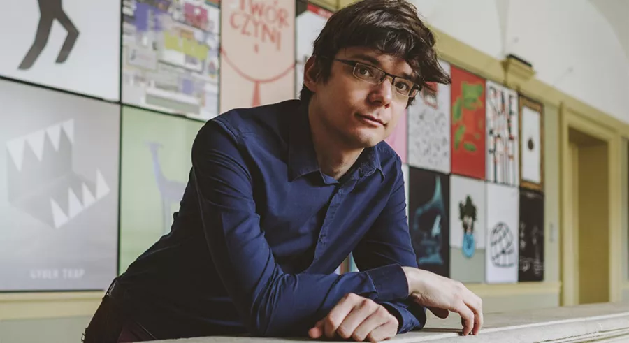 Filip Presseisen leans on a balustrade facing the camera.