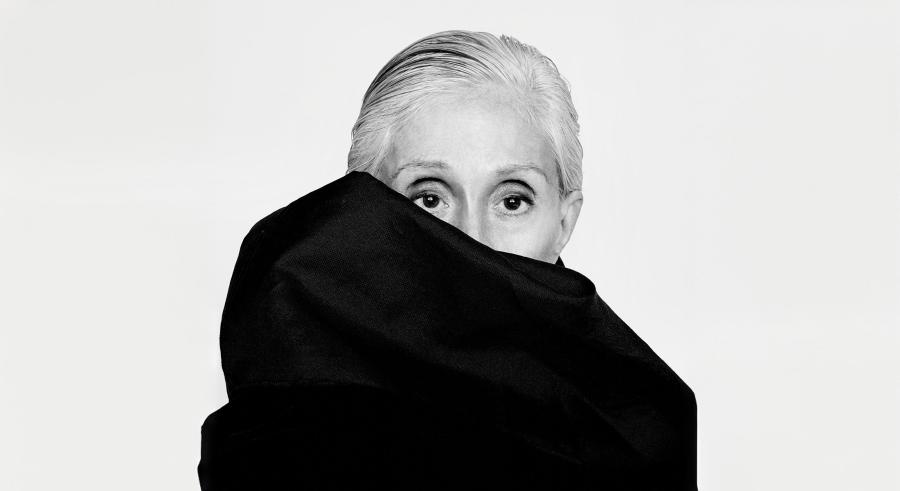 Twyla Tharp wraps a black shawl around her head, covering the lower half of her face.