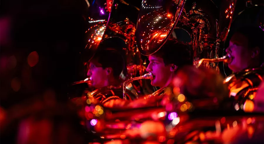 Close up shot of tuba players lit red on stage.