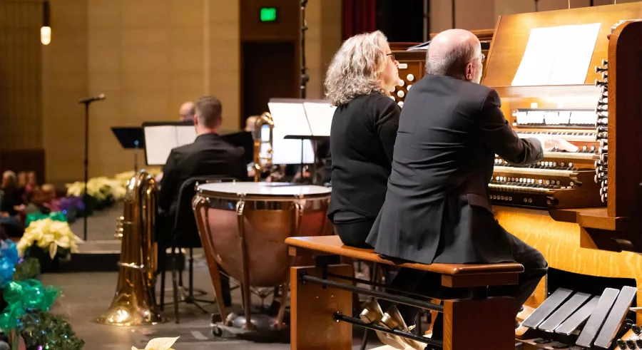 Two people sit at the Aeolian Skinner pipe organ