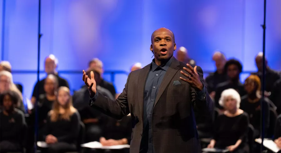 G. Philip Shoultz III raises both arms as he conducts.