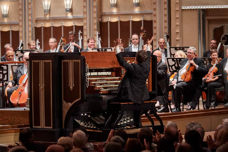 Paul Jacobs plays the organ on stage in front of a full orchestra.