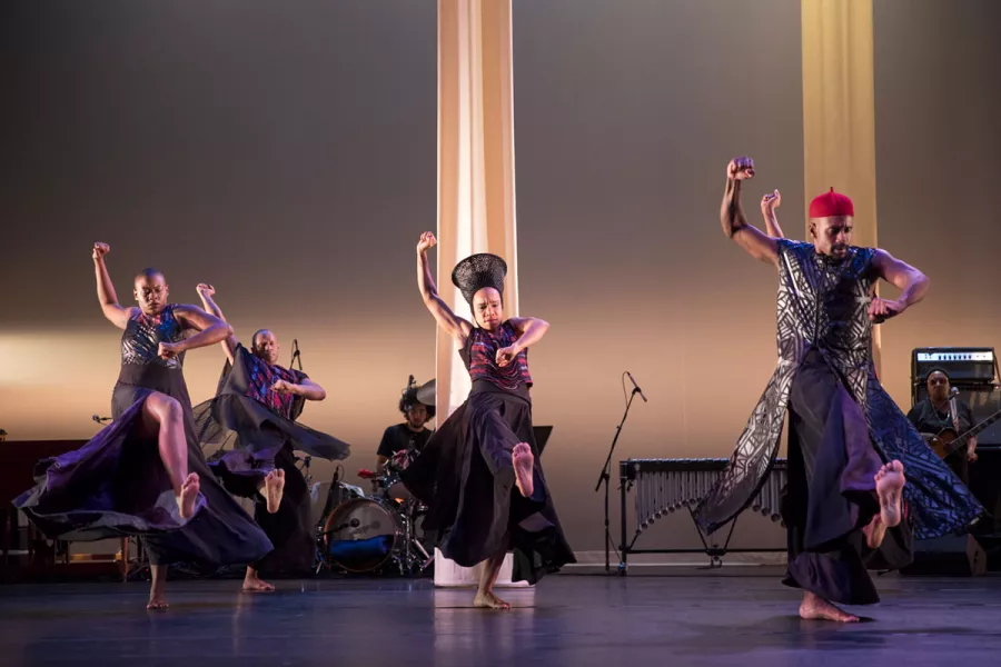 A group of dancers perform together on stage.