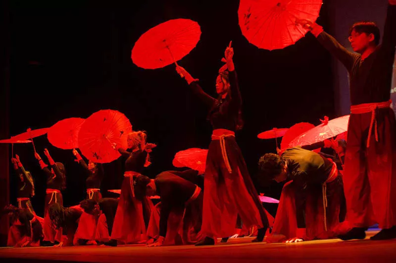 Traditional dance with red umbrellas