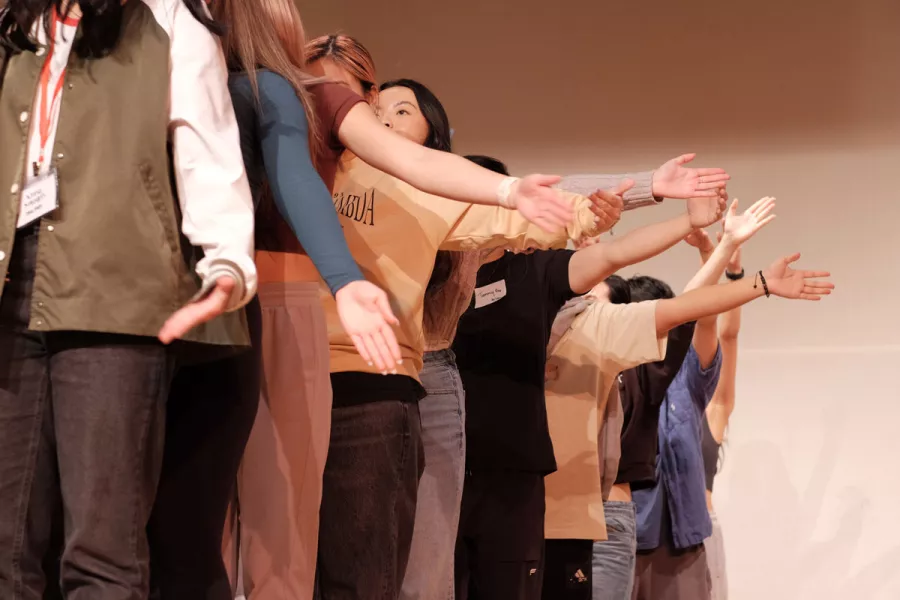 closeup of people lined up with their arms out to the side